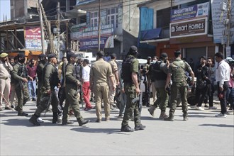 Police personnel managing a crowd in an urban street, ensuring security and order, Jammu and