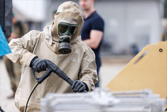 German soldiers from an NBC defence unit in protective clothing practise decontamination during the