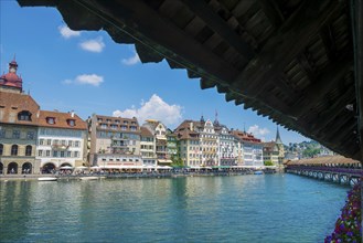 River Reuss with Chapel Bridge and Old Buildings with Blue Sky and Clouds in a Sunny Day in City of