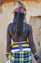 Hakaona woman with traditional kapapo hairstyle and hair ornaments with ostrich feathers, and