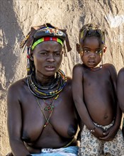 Hakaona woman with traditional kapapo hairstyle and colourful necklaces, with child, portrait, in