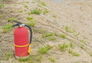 Red portable fire extinguisher on ground of rural construction site in Daejeon, South Korea, Asia