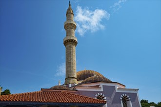 Suleiman Mosque, minaret and dome under blue sky with few clouds, red roofs and historical