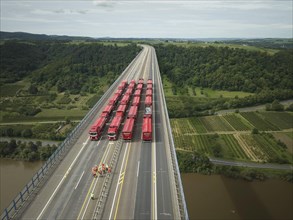 Trucks with a total weight of 960 tonnes stand on the Moselle valley bridge in Winningen during a