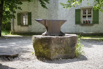 A classic anvil stands on a stone in front of a forge, Neuhausen ob Eck open-air museum, Tuttlingen