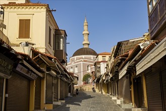 Suleiman Mosque, Historic street with closed shops and a minaret in the background in sunny
