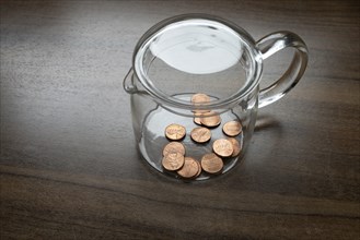 A glass container, money box, with some one cent pieces, American dollar cent, US currency, symbol