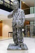 A bronze sculpture of a standing man in a modern style in a bright interior, Willy-Brandt-Haus, SPD