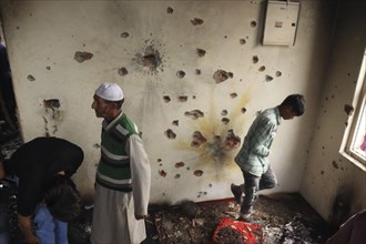 People in a room with a wall full of bullet holes, depicting the aftermath of violence, Encounter,