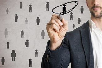Man drawing a circle around a person from a group. Human resources concept