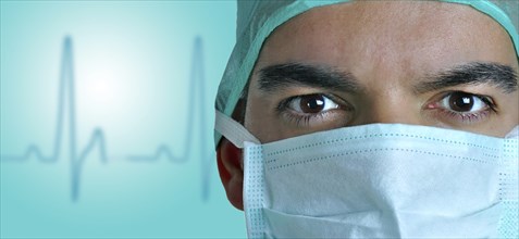 Closeup portrait of a surgeon with a EKG wake behind him. Blue color cast on the doctors face