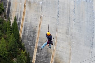 Child on zipline above reservoir dam, Barrage de Emosson, Finhaut, Switzerland, Europe