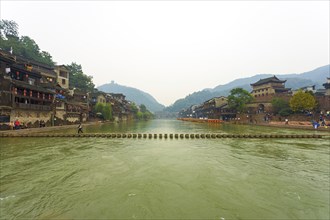 Fenghuang, China, September 10, 2007: A stepping stone bridge spans the Tuojiang River which cuts