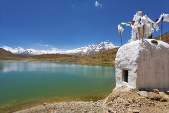 A stupa stands at the edge of a pristine mountain lake used by Buddhist pilgrims near Dhankar,