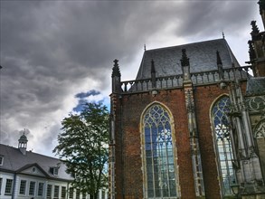 Church with Gothic architecture and high windows against a dramatic, cloudy sky, zutphen,