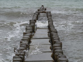 Wooden groynes extend into the sea and are lapped by waves, ahrenshoop, zingst, Baltic Sea,