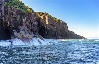 Cliff over the sea waters on the island of Ilhabela in Sao Paulo, Ilhabela, Sao Paulo, Brazil,