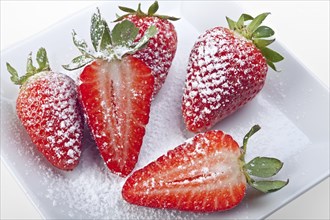 Handful of strawberries with icing sugar