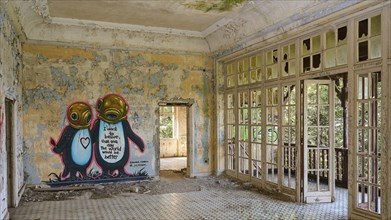 Abandoned room with graffiti on the wall, tiled floor and nature view through the windows,