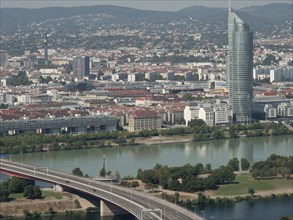 Panorama of an urban landscape with a dominating skyscraper next to a river, Vienna, Austria,