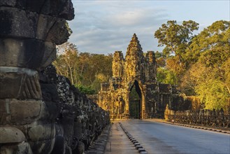Stone Gate of Angkor Thom in Cambodia illuminated by the setting sun