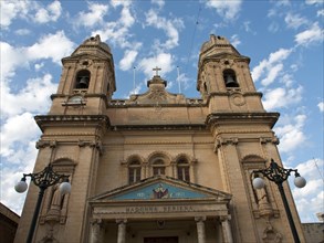 Front view of a church with two towers under a partly cloudy sky, valetta, mediterranean sea, malta