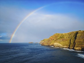 Colorful rainbow arching over the coastline of the azorean island San Miguel