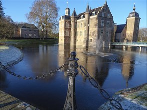 Winter view of a castle with frozen water and decorated chain in the foreground, ruurlo,