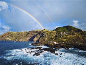 Colorful rainbow arching over the coastline of the azorean island San Miguel