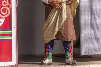 Spectator in traditional colorful clothing at a tshechu festival in Bhutan