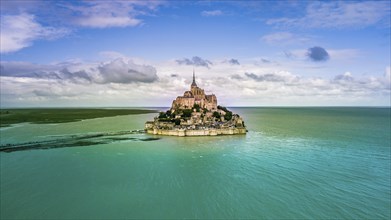 Le Mont Saint-Michel tidal island with deep blue water in golden evening light