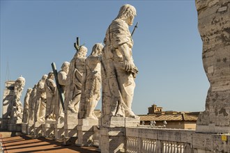 Back view of statues of the saints apostles located on the top of Saint Peter Basilica roof