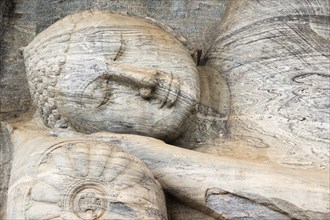 A closeup of the monolithic reclining Buddha statue, the Gal Viharaya, carved from a single piece