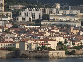 Coastal view of a town with many buildings and flat blocks and a cloudy sky, ajaccio, corsica,