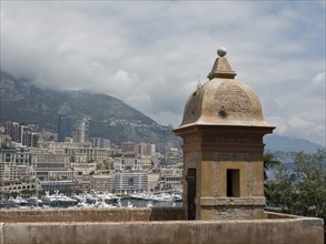 View of a harbour district with historic towers and a densely populated city, surrounded by