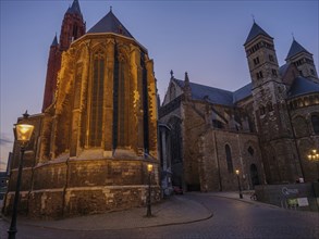 Illuminated cathedral at dusk, quiet street with lanterns, Maastricht, limburg, netherlands