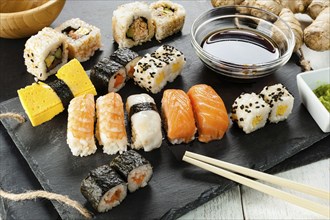 Black slate tray of assorted sushi and rolls