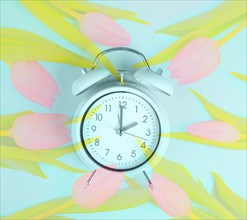 Alarm clock with tulips, switch to daylight saving time in spring, summer time changeover