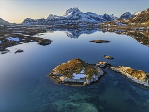 Aerial view of fjord, steep mountains, coast, island, winter, morning light, reflection,