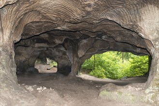 El Huel Lee or Hohllay on the Mullerthal trail in Luxembourg, open cave with view to the forest,