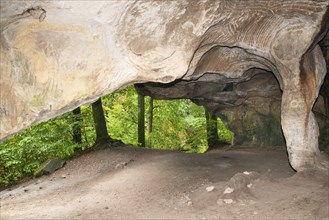 Huel Lee or Hohllay on the Mullerthal trail in Luxembourg, open cave with view to the forest,