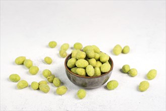 Pile of green wasabi coated peanuts in a bowl, spicy snack, oriental food