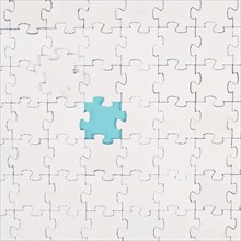 White jigsaw on a blue background, missing parts, working together as a team, searching for