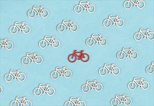 Many small bicycles, one red is standing out, leadership concept, think different, minimalistic