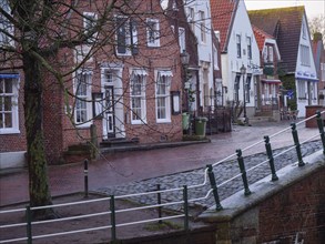 A picturesque old town street with traditional brick houses and cobblestones at dusk, greetsiel,