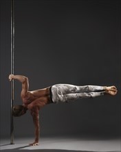 Studio image of professional male athlete performing on pylon