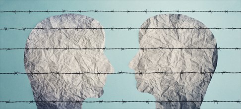 Two silhouettes of faces look at each other behind a barbed fence, refugee camp, prisoners