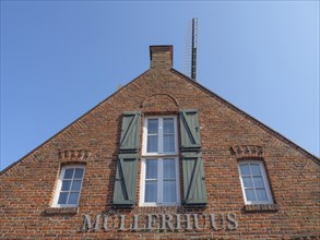 Brick house with green shutters and Müllerhaus lettering, Ditzum, rheiderland, Lower Saxony,