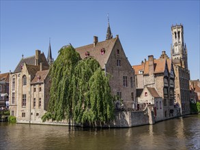 Historic riverside buildings under a blue sky, a picturesque and peaceful atmosphere, Bruges,