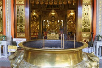 Large golden censer in front of an ornate Buddhist temple interior, Pattaya, Thailand, Asia